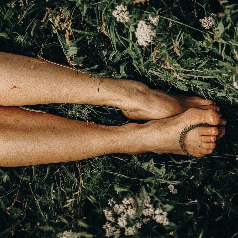 persons feet on white flowers